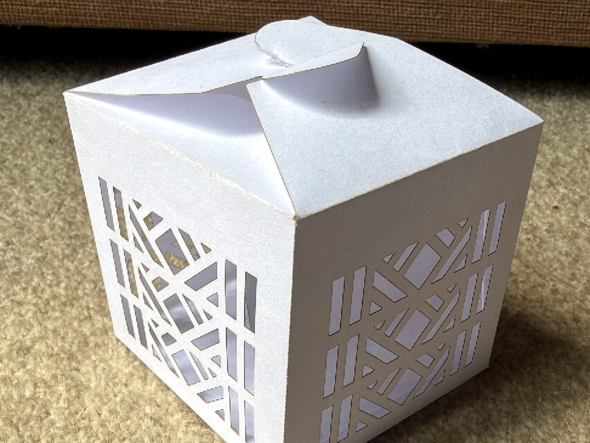 Intricately laser-cut white paper lantern favour box